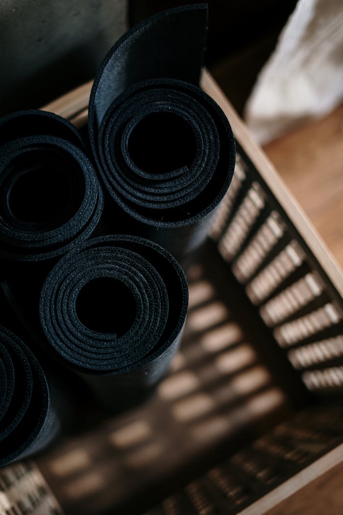 services-01 Close-up of rolled yoga mats in a basket at a fitness studio, ideal for yoga or pilates.